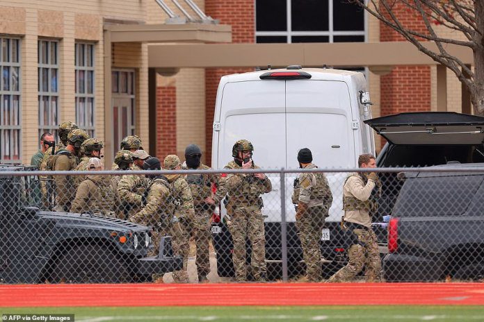 A SWAT team has set up by a nearby middle school as the hostage situation enters its fifth hour